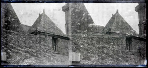 Gargouille au coin d'un toit quatre pentes de la tour d'une église bretonne.