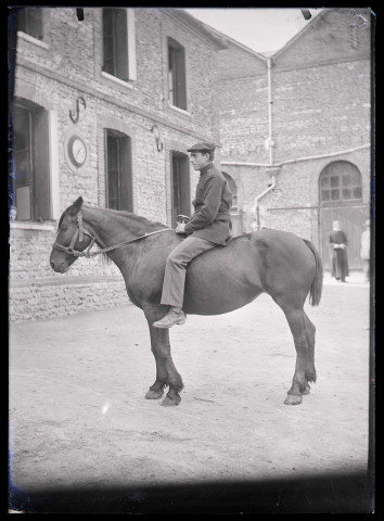 Militaire français à cheval dans la cour de la maison fermière d'Orgeville (Eure).