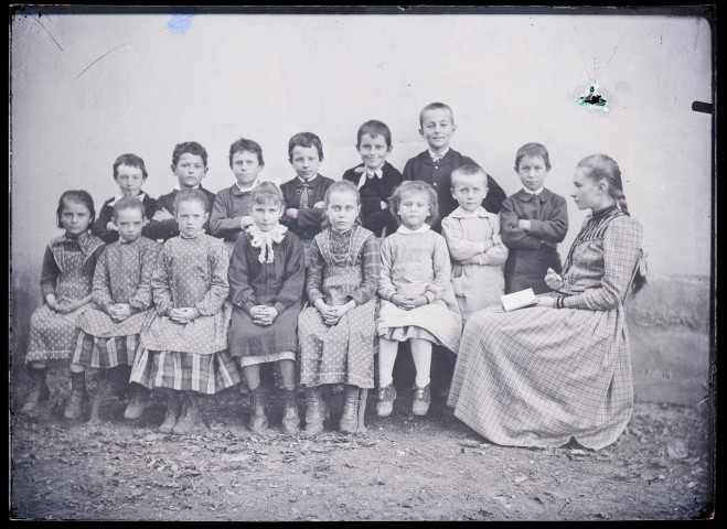 Melle Bonjean avec un groupe d'enfants dans un jardin.