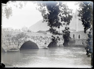 Pont en pierre traversant un fleuve et minaret.