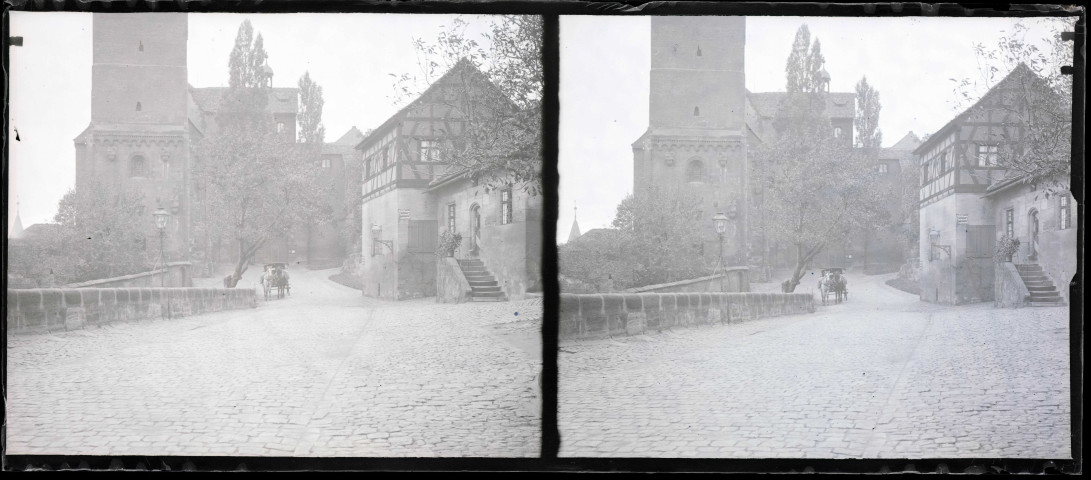 Carriole dans une rue de village devant une église, probablement en Alsace.