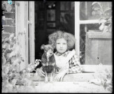 Portrait d'une petite fille et un petit chien à une fenêtre. (famille Bretocq).