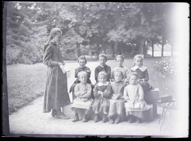 Melle Bonjean avec un groupe d'enfants dans un jardin.
