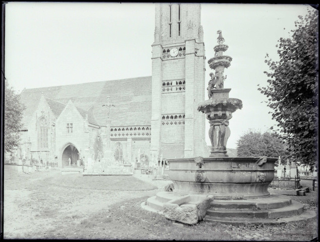 Église bretonne et fontaine ornementée.