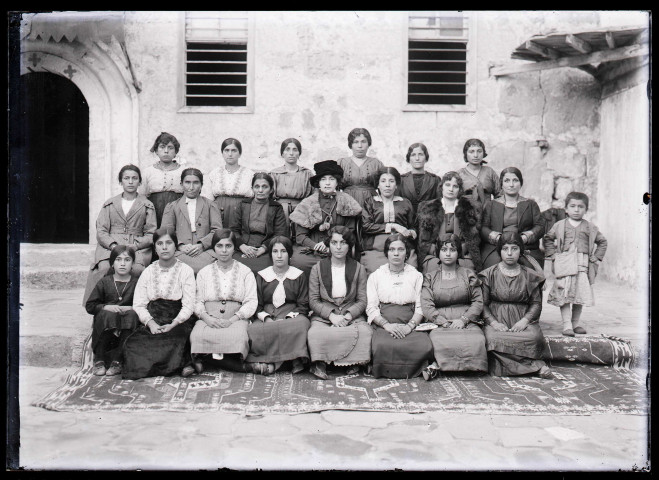 Mme Taillardat, femme du gouverneur de Kozan (Sis) (Turquie), avec un groupe de jeunes femmes dans la cour d'une demeure chrétienne à Antioche (Turquie) (notice PA).