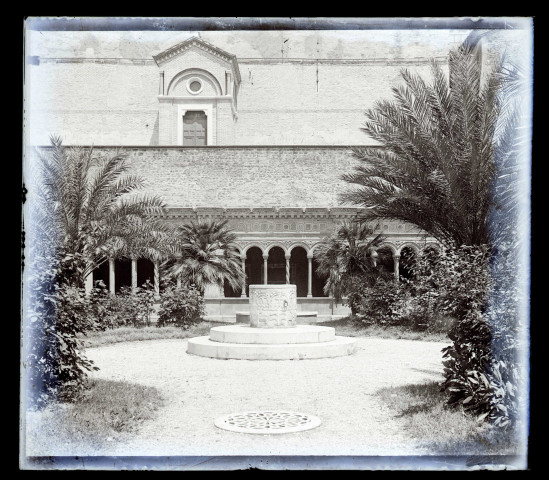 Cour intérieure avec puits, jardin et galerie à arcades.