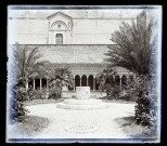 Cour intérieure avec puits, jardin et galerie à arcades.