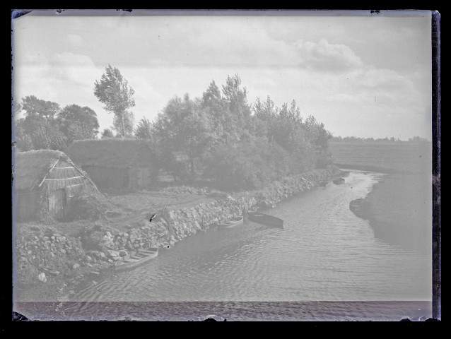 Chaumières le long d'une rivière traversant la campagne bretonne.