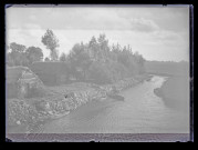 Chaumières le long d'une rivière traversant la campagne bretonne.