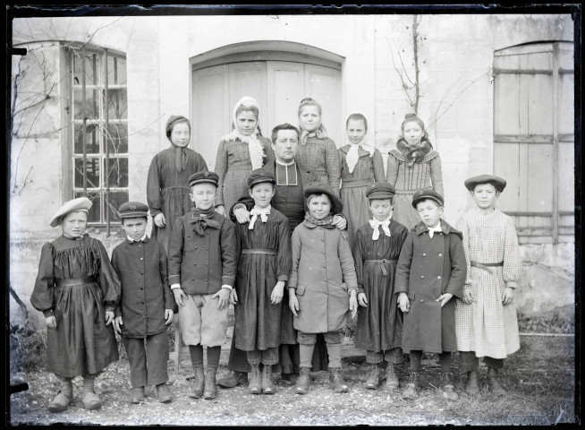 L'abbé Gabriel Bretocq au milieu d'un groupe de jeunes enfants déguisés.