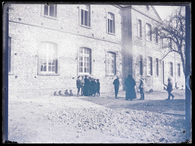 Femme et enfant dans la cour du bâtiment Saint-Maurice d'Orgeville (Eure).