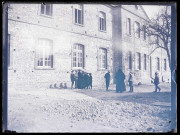Femme et enfant dans la cour du bâtiment Saint-Maurice d'Orgeville (Eure).