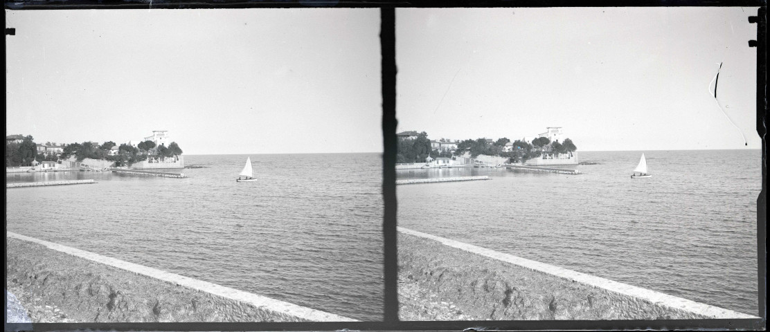 Voilier dans la baie d'un port méditerranéen.