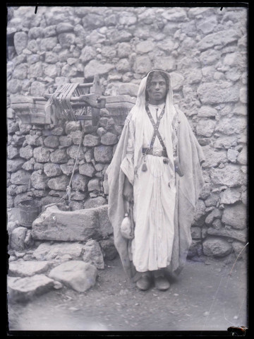 Homme en costume traditionnel au puits.