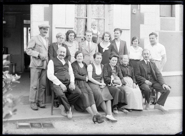 Famille Bretocq et amis posant devant une habitation de campagne.