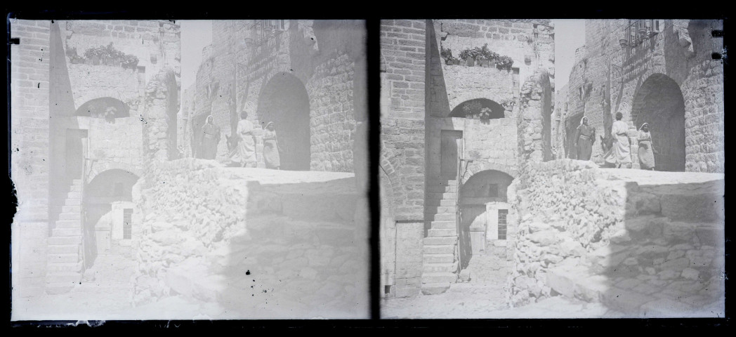 Façade d'une habitation en pierre à plusieurs niveaux.