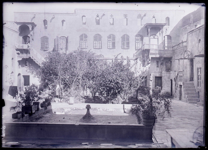 Façade et cour carrée d'une habitation traditionnelle.