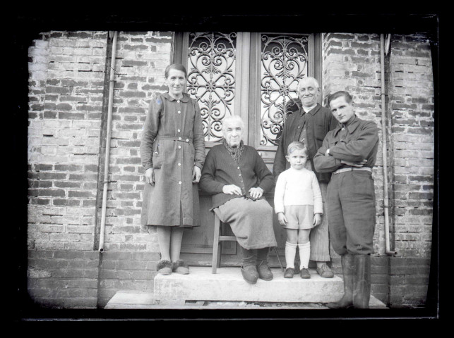 Famille sur le perron d'une maison.