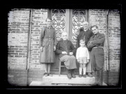Famille sur le perron d'une maison.