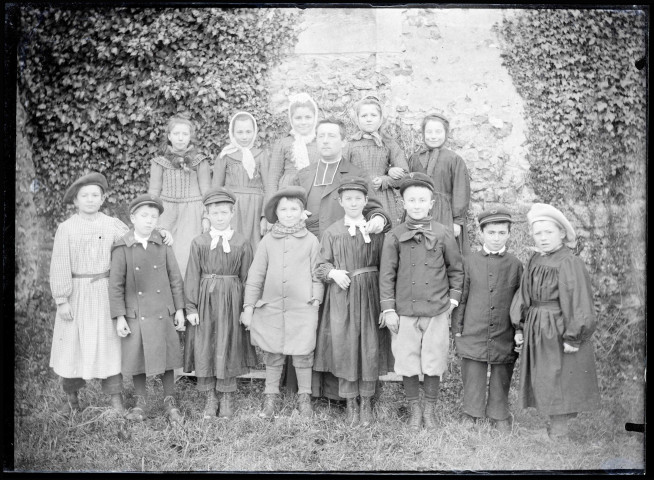 L'abbé Bretocq entouré d'un groupe d'enfants costumés.
