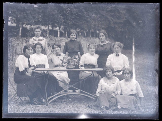 Femmes attablées dans un jardin.