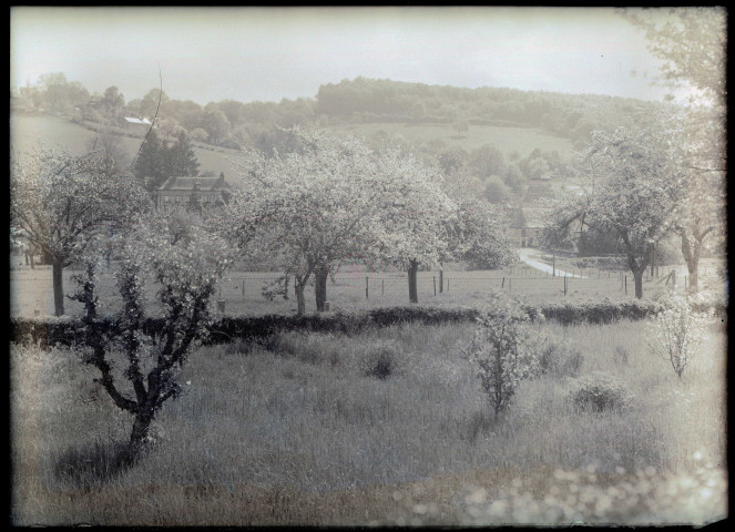 Vue sur le Prieuré de Rosay-sur-Lieure (Eure) depuis un verger en fleurs.