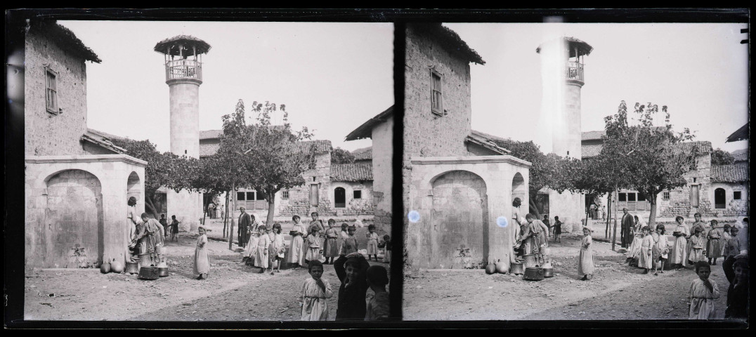 Enfants à la fontaine au pied d'un minaret d'Antioche (Turquie).