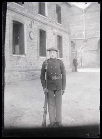 Militaire français armé d'un fusil à baïonnette dans la cour de la maison fermière d'Orgeville (Eure).