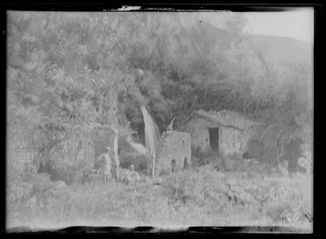 Groupe d'hommes dans la campagne devant les vestiges d'une habitation à Daphné (Turquie).