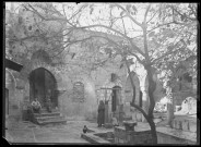 Femme et enfants dans une cour auprès d'un puits.