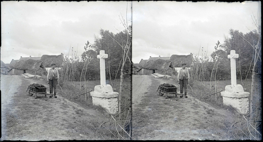Paysan et sa brouette près d'un calvaire.