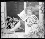 Portrait d'une petite fille lisant assise sur un appui de fenêtre. (famille Bretocq).