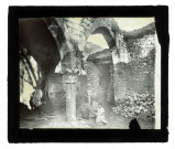 Homme et des jeunes enfants dans des ruines et vestiges (arcades, chapiteaux).