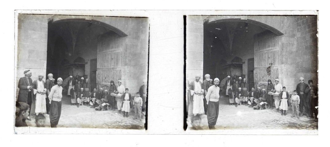 Petits commerçants assis à la porte d'une ville de Syrie.