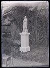 Statue d'un saint dans un jardin, probablement Saint-Jérôme.