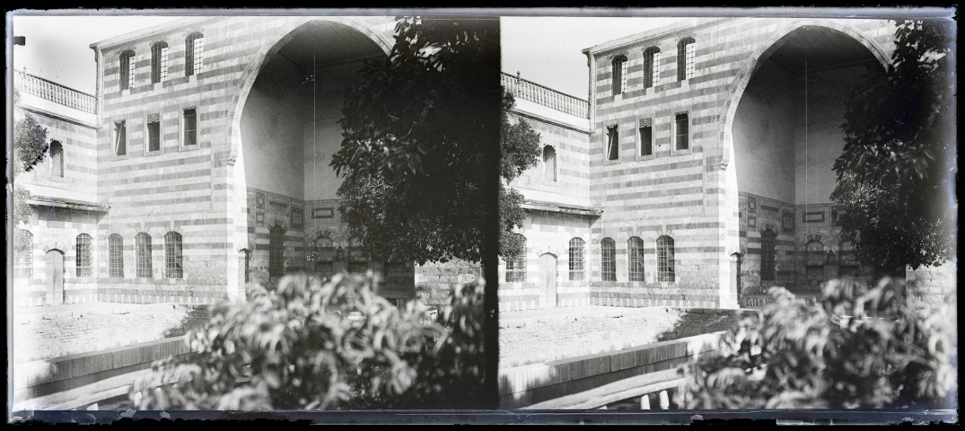 Façade ornementée et jardin d'une habitation.