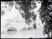 Pont en pierre traversant un fleuve et minaret.
