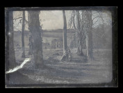 Jeune femme et petites filles assises sur la grume d'un arbre abattu dans la campagne normande.