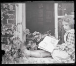 Portrait d'une petite fille lisant assise sur un appuie de fenêtre. (famille Bretocq).