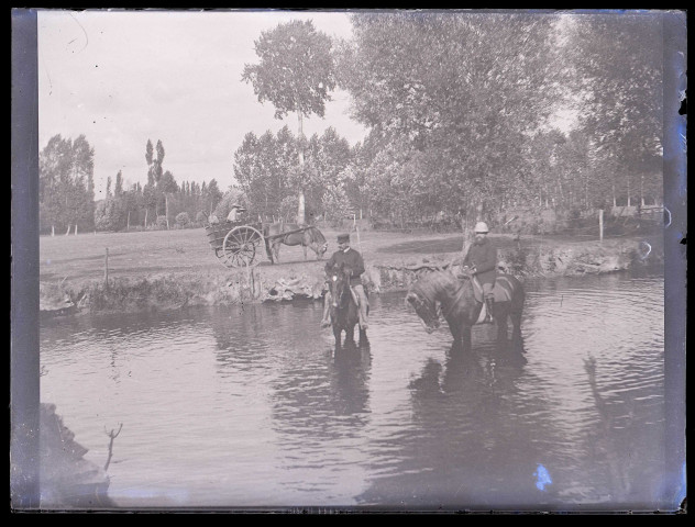 Hommes à cheval dans un plan d'eau.
