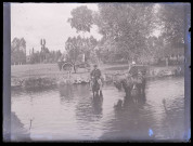 Hommes à cheval dans un plan d'eau.
