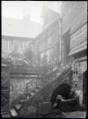 Arrière cour avec puits et escalier de pierre d'une maison à pans de bois de Lisieux (Calvados).