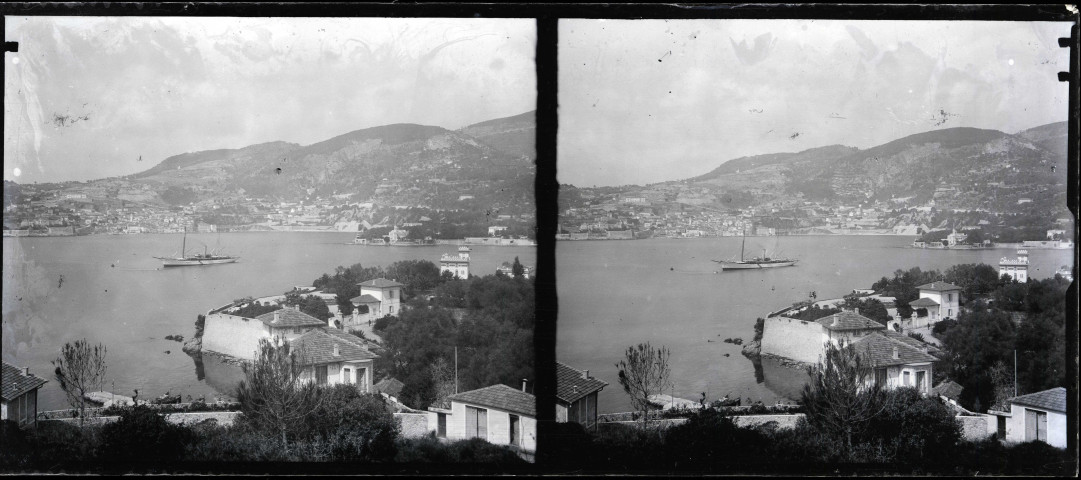 Voiler de plaisance au loin dans la rade d'un port méditerranéen.