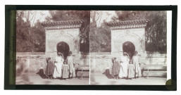 Mouquères devant la porte ornementée d'un jardin public d'Alger (Algérie).