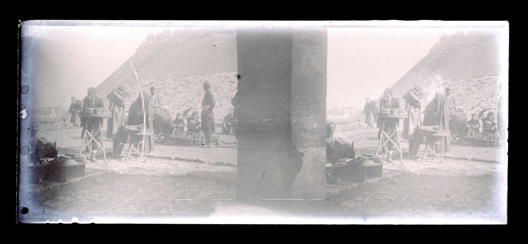 Scène de marché au pied d'une forteresse.