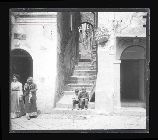 Jeunes enfants assis dans une ruelle en escalier d'un village de Sicile (Italie).