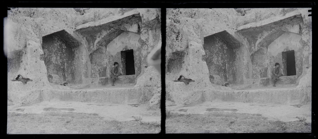 Enfant posant devant un tombeau dans une grotte.
