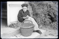 La mère de l'abbé Gabriel Bretocq épluchant des haricots verts sur le perron du presbytère de Rosay-sur-Lieure (Eure).