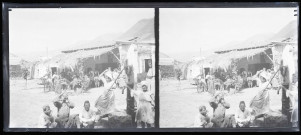 Femmes et enfants à la fontaine devant la terrasse d'un café.