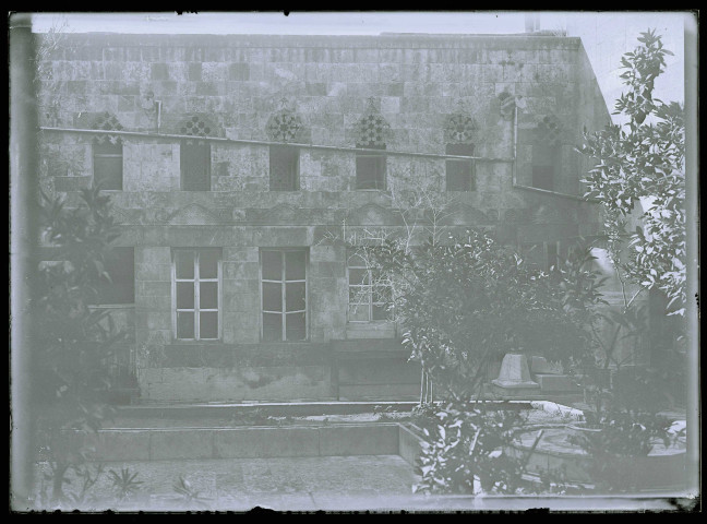 Façade d'habitation avec son jardin et sa fontaine.